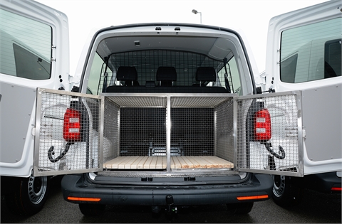 Vehicle, trailer and a cage for transportation of service dogs