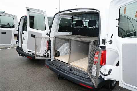 Vehicle, trailer and a cage for transportation of service dogs